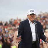 Donald Trump wearing a white USA baseball cap