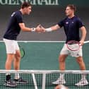 Henry Patten, left, and Neal Skupski touch hands