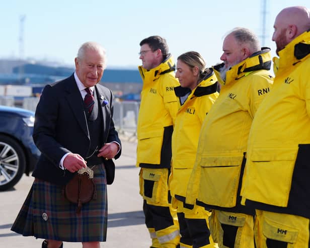 Charles meeting four RNLI volunteers, who are dressed in yellow