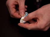 A person's hands holding a wrapper with Ketamine in it