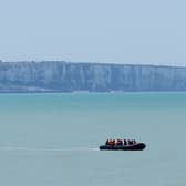 A small boat hugs the coastline near Ault in France