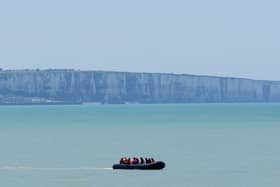 A small boat hugs the coastline near Ault in France