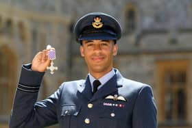 Chris Gordon in uniform holding up a medal