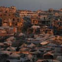Dozen of tents amid war-damaged buildings in the background