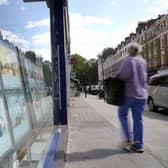 person walking past estate agents
