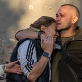 A man hugs a woman after recognizing the body of his grandmother, who was killed in a Russian airstrike on a residential neighborhood in Kharkiv