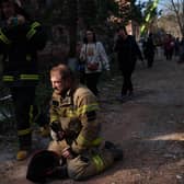 Locals and rescuers clear the rubble of a residential building destroyed in a Russian missile strike, in photos