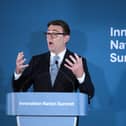 Andy Burnham speaking from behind a lectern