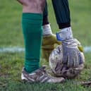 A goalkeeper bending down near the corner flag