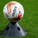 A football resting on a training cone