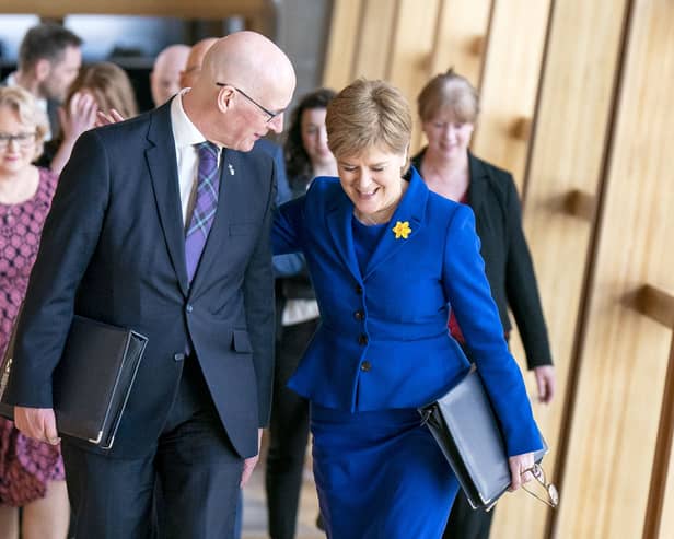 John Swinney and Nicola Sturgeon walking side by side and smiling as they chat