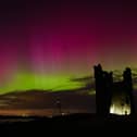The aurora borealis lighting up skies over the ruins of Dunstanburgh Castle
