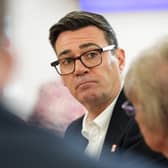 Andy Burnham, viewed between the backs of two people