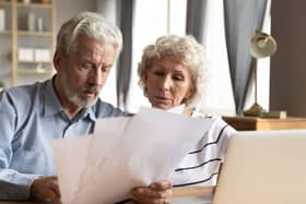 Old man and wife looking at energy bills
