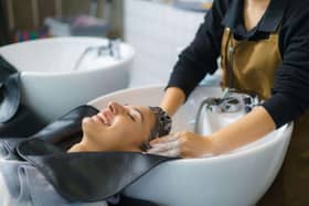 A hairdresser applying shampoo and massaging the hair of a customer