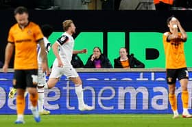 Dejected Wolves men Adam Armstrong (left) and Hugo Bueno (right) as Sam Dalby celebrates scoring for Bolton