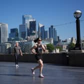 A woman runs with a city skyline in the background