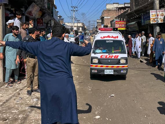 A volunteer clears the way for an ambulance