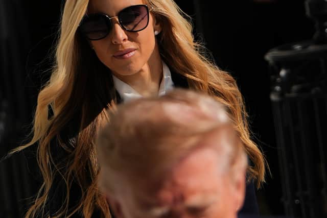White House press secretary Katie Zacharia watches as US President Donald Trump speaks with reporters before boarding Marine One (Julia Demaree Nikhinson/AP)