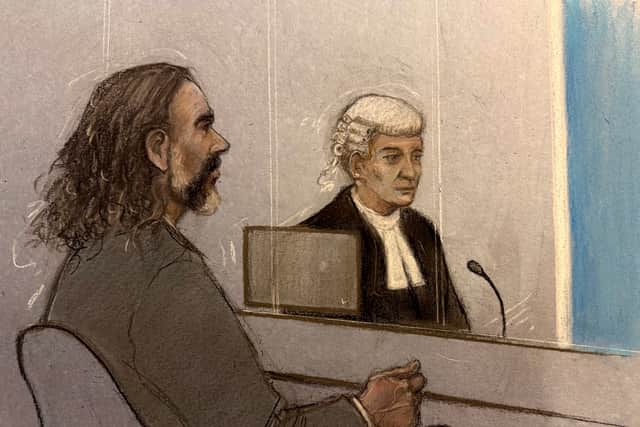 Court artist sketch of Russell Brand and barrister Riel Carney-Jones KC listening to witness evidence being given from behind the blue screen at Southwark Crown Court (Elizabeth Cook/PA)