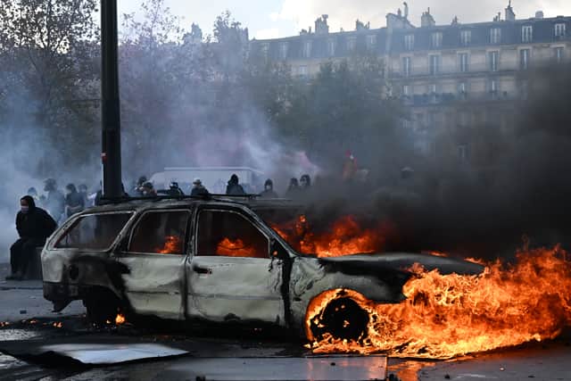 A car burns at Place de La Republique during a protest against rising living costs (AP)