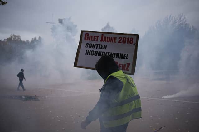 A protesters holds a placard reading: ‘Yellow vests 2018, unconditional support’, during a demonstration in Lyon (AP)