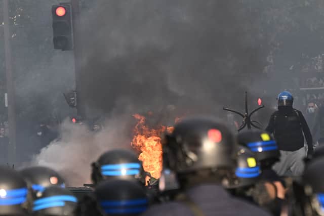 Police officers face protesters during a demonstration in Paris (Emma Da Silva/AP)