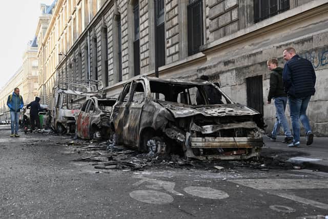 People look at charred cars in Paris (Emma Da Silva/AP)