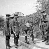 Members of Shrewsbury Borough Police Force in 1937, when policemen doubled as firemen. The location is possibly Bicton Heath and they appear to be checking a fire hydrant or piece of equipment. Left is Tom Davies, then Tom Meredith. Far right is Ieuan Lloyd. Jack Laird is thought to be the person bending down with “Bomber” Mills hidden second from right