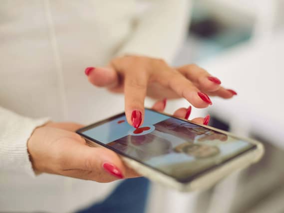 Hands of a young female choosing a boyfriend or possible husband in online dating application