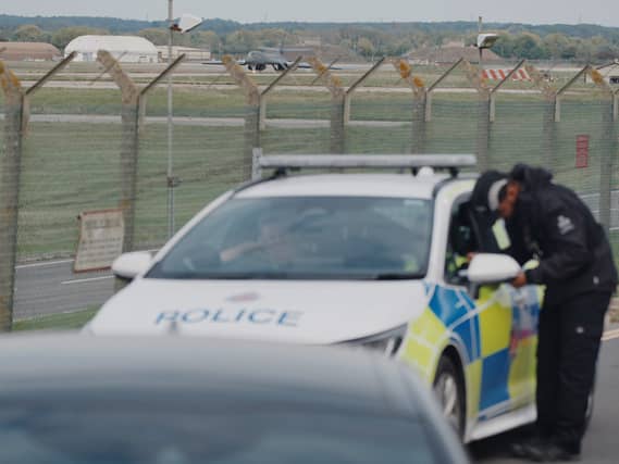 Police patrol the perimeter as a US Air Force Rockwell B-1 Lancer bomber lands at RAF Fairford