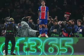 Vitinha stands on an advertising hoarding to celebrate after scoring in Paris St Germain's win over Barcelona