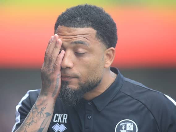 Crawley manager Colin Kazim-Richards puts a hand on his face in frustration