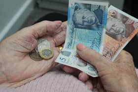 A woman holding coins and banknotes