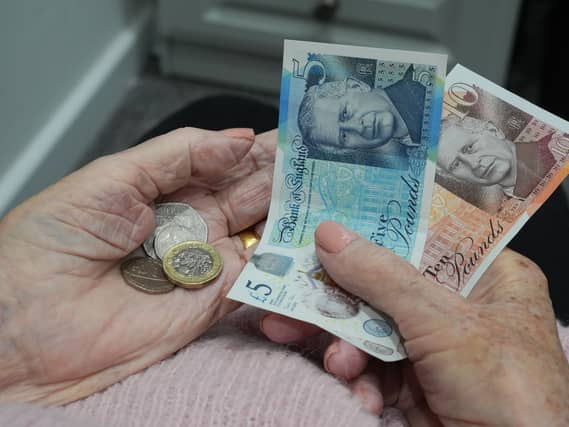 A woman holding coins and banknotes