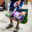 A shopper holding a basket in a supermarket