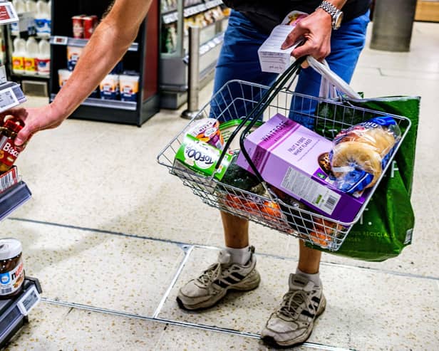 A shopper holding a basket in a supermarket