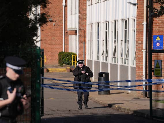 Police officers and police tape outside a school