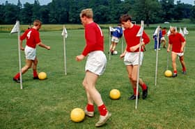 PICTURE FROM THE ARCHIVE: Members of England’s 1966 World Cup squad - Peter Thompson, Ron Flowers, Martin Peters, and Bobby Charlton, weave through slalom poles with footballs during an intensive training session at Lilleshall Hall in Shropshire. The national sports centre served as the quiet, secluded base where manager Sir Alf Ramsey put his squad through their paces ahead of their historic World Cup victory later that summer.