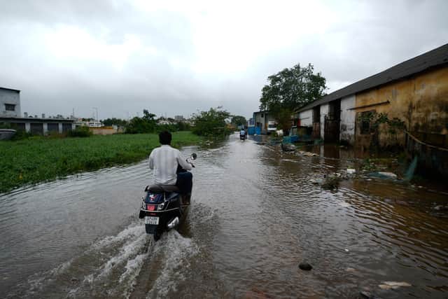 People navigate floodwaters after Cyclone Arnab crossed the Andhra Pradesh coast (Mahesh Kumar A/AP)