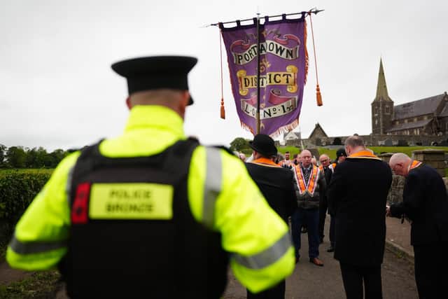Orangemen make their way from Drumcree Church as police form a barricade to prevent them entering the Garvaghy Road during the stand-off (Brian Lawless/PA)
