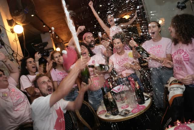 People spray sparkling wine as they celebrate the early exit poll results in Tel Aviv (Oded Balilty/AP)