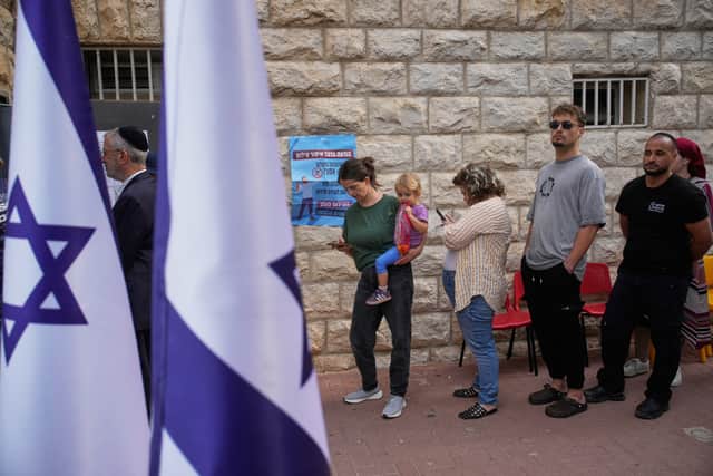 Voters line up to cast their ballots at a polling station during Israel’s general election (Ohad Zwigenberg/AP)