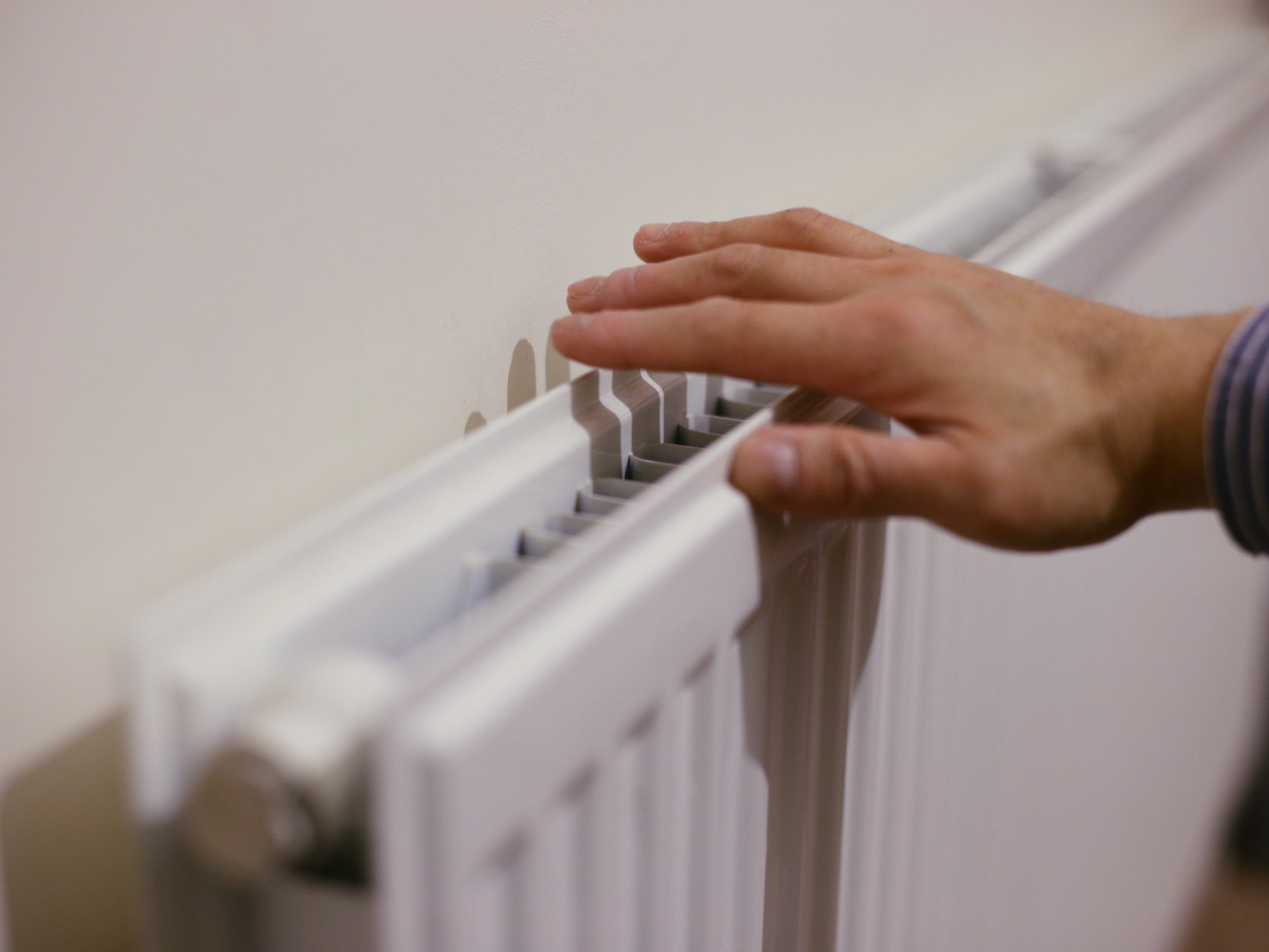 A hand touching a radiator