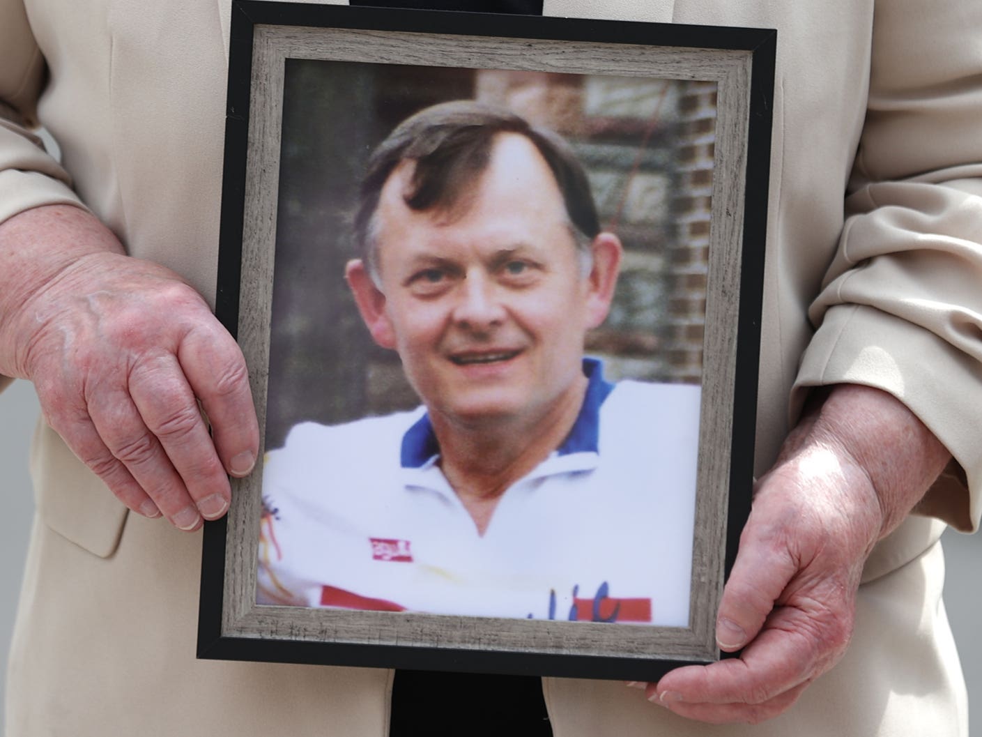 Bridie Brown, the widow of murdered GAA official Sean Brown, holds a picture of him, outside the Royal Courts of Justice in Belfast