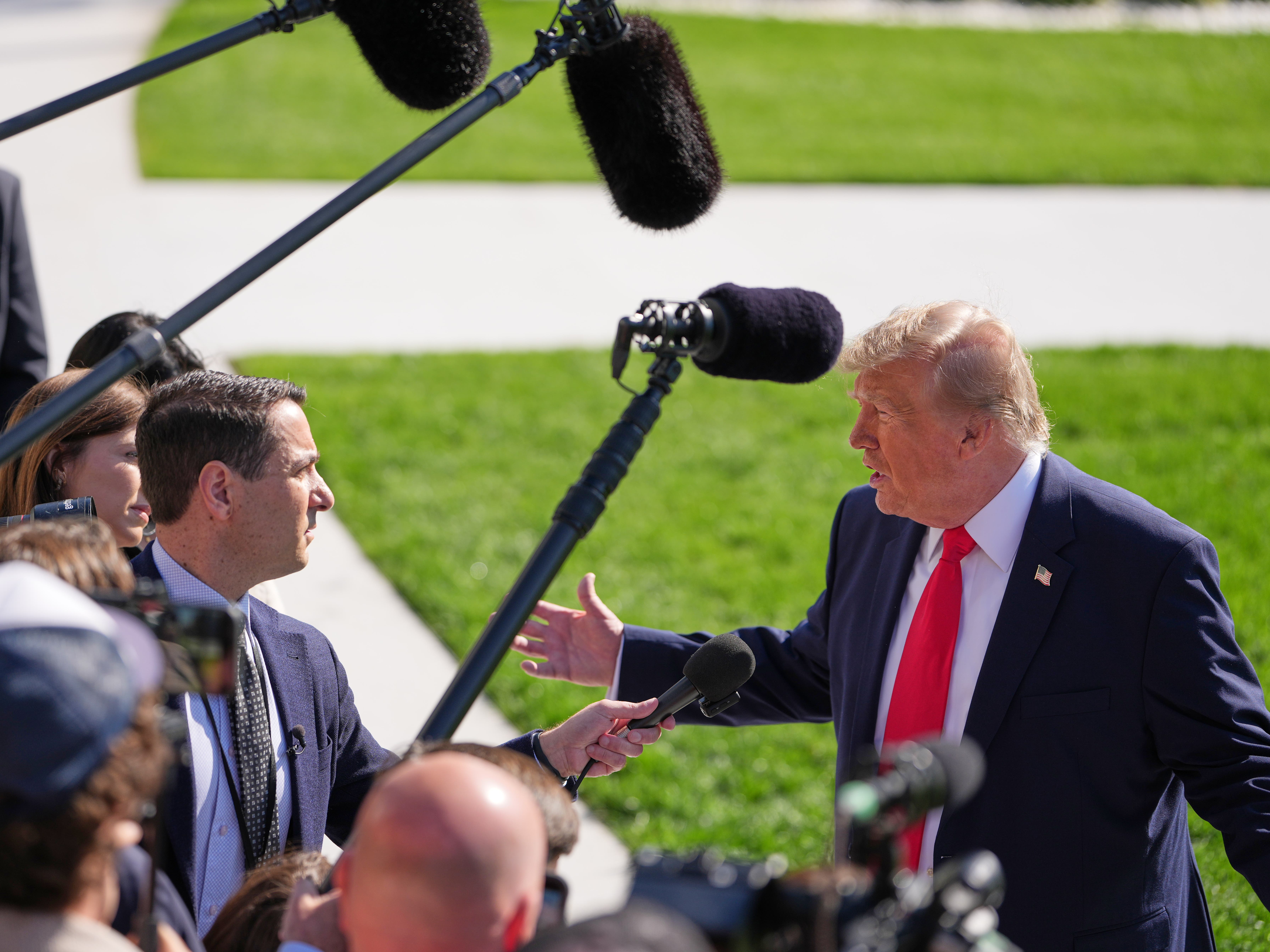 Donald Trump, right, fielding questions from reporters