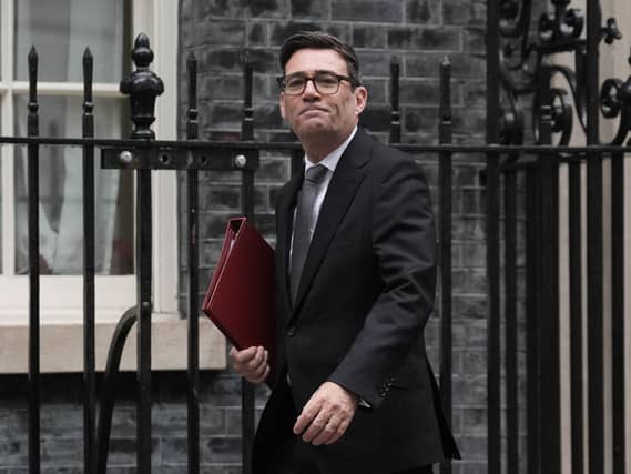 Andy Burnham walking along Downing Street carrying a folder under his arm