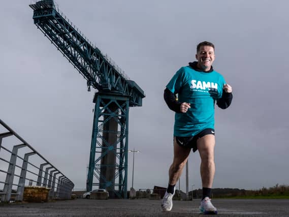 Shaun Ellis running with crane in background