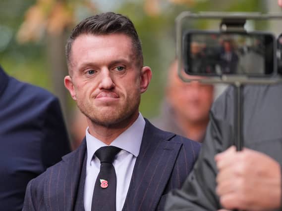 Tommy Robinson walking outside, being filmed on a smartphone