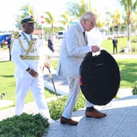 King honours fallen troops in solemn start to second day of Caribbean tour